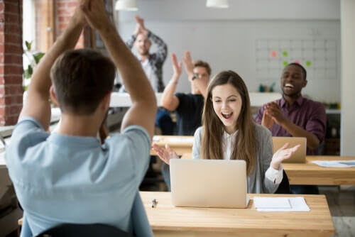 An excited sales team use sales motivation tools to get work done.