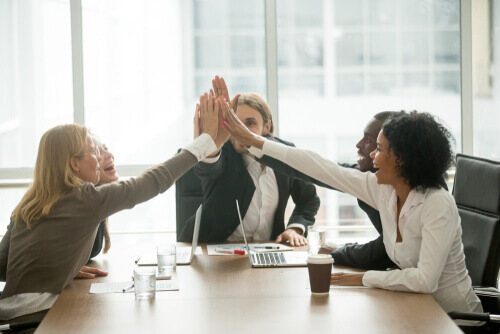 A sales team high fives for motivation